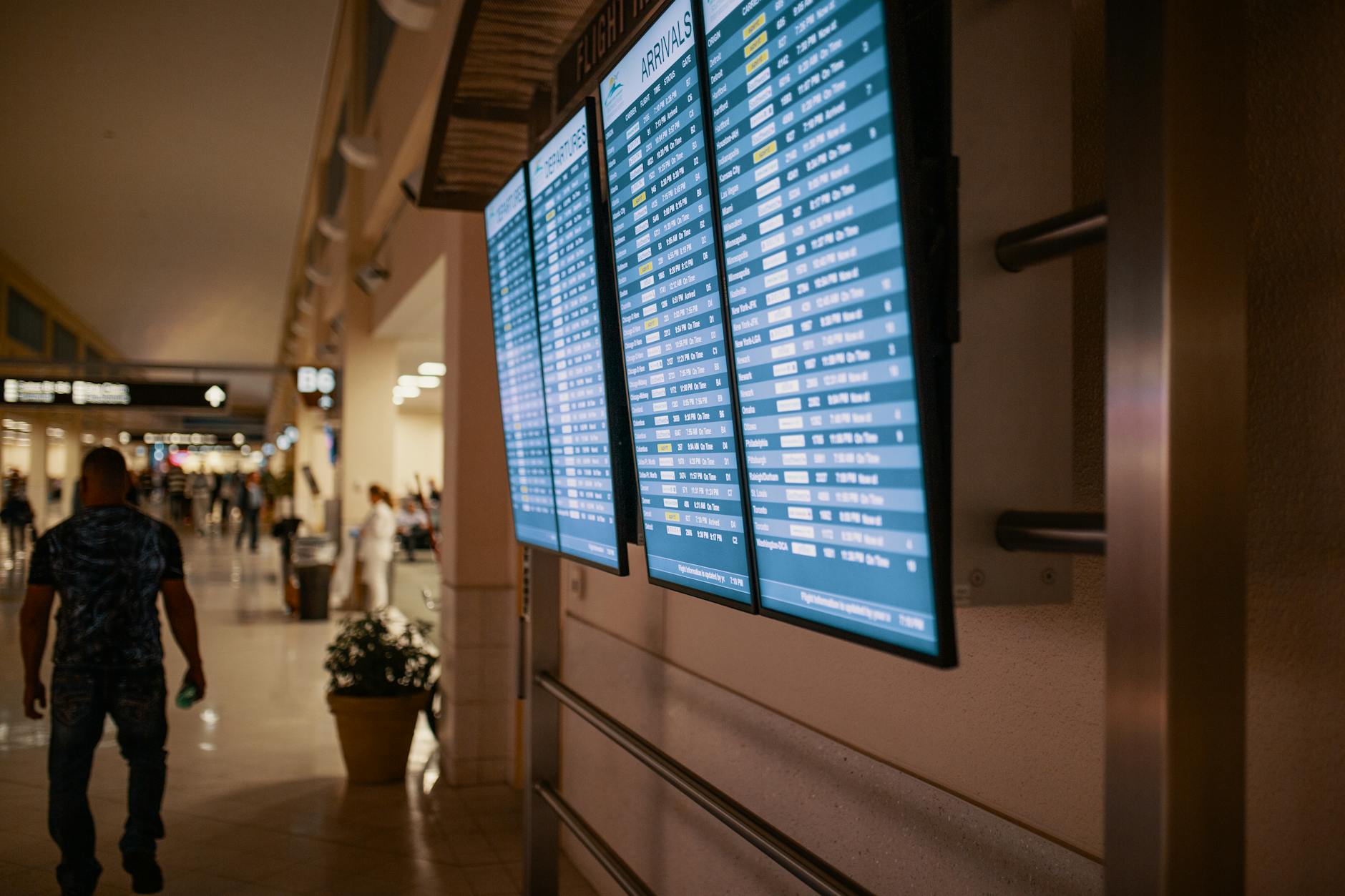 Modern airport terminal interior with departures board and passengers