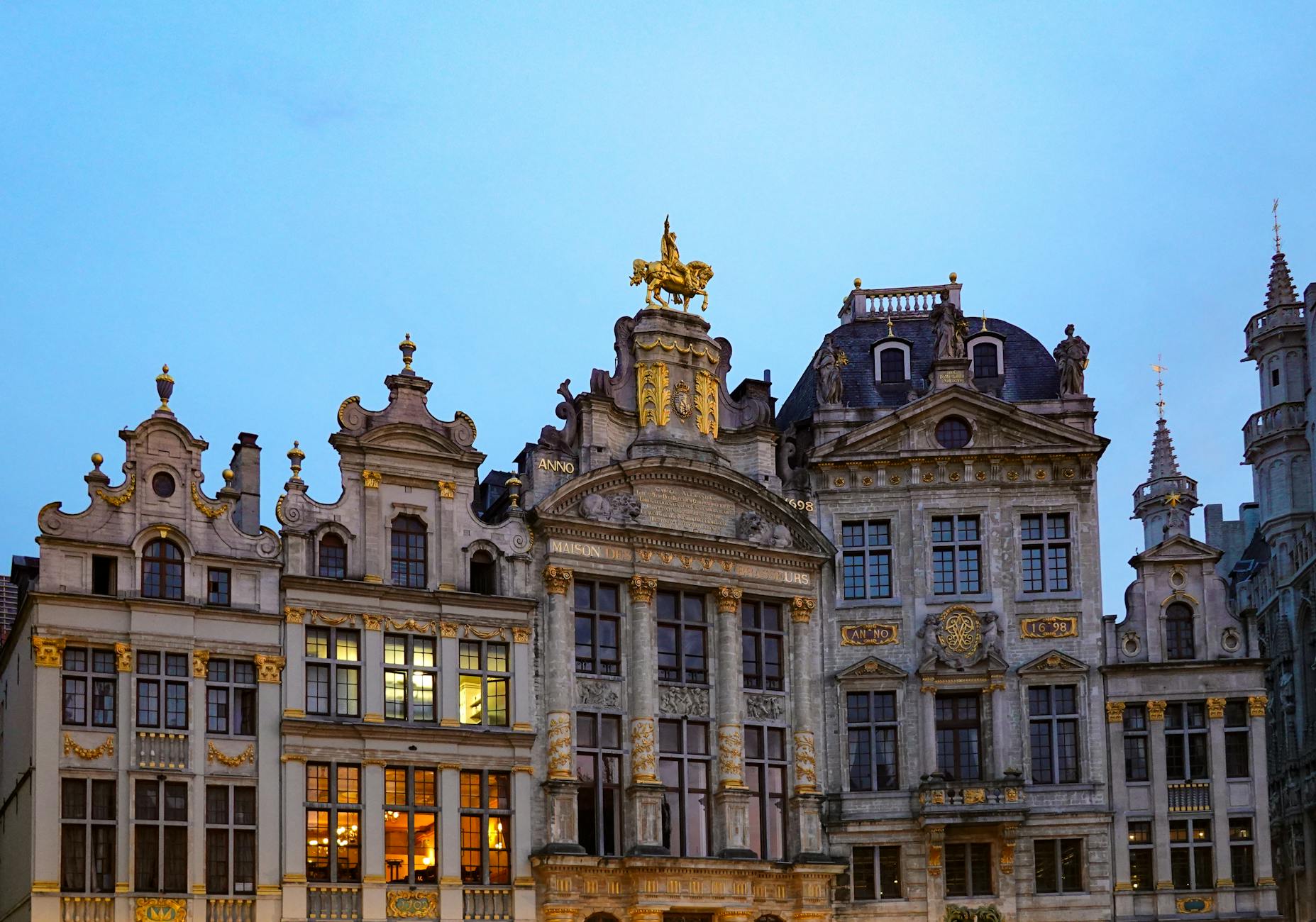 The stunning Grand Place square in Brussels with ornate guild houses illuminated at golden hour