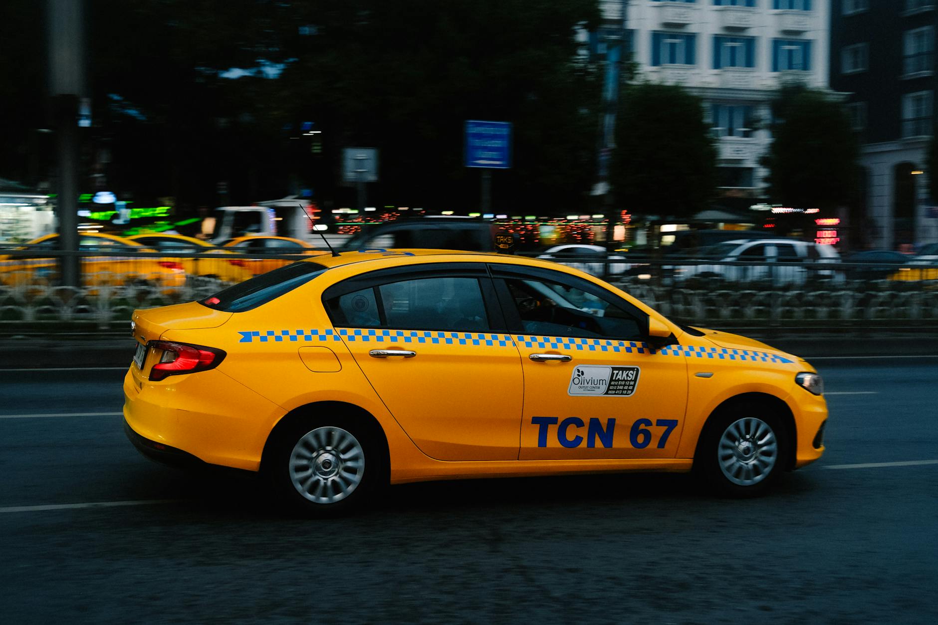 A yellow taxi cab driving through a city street